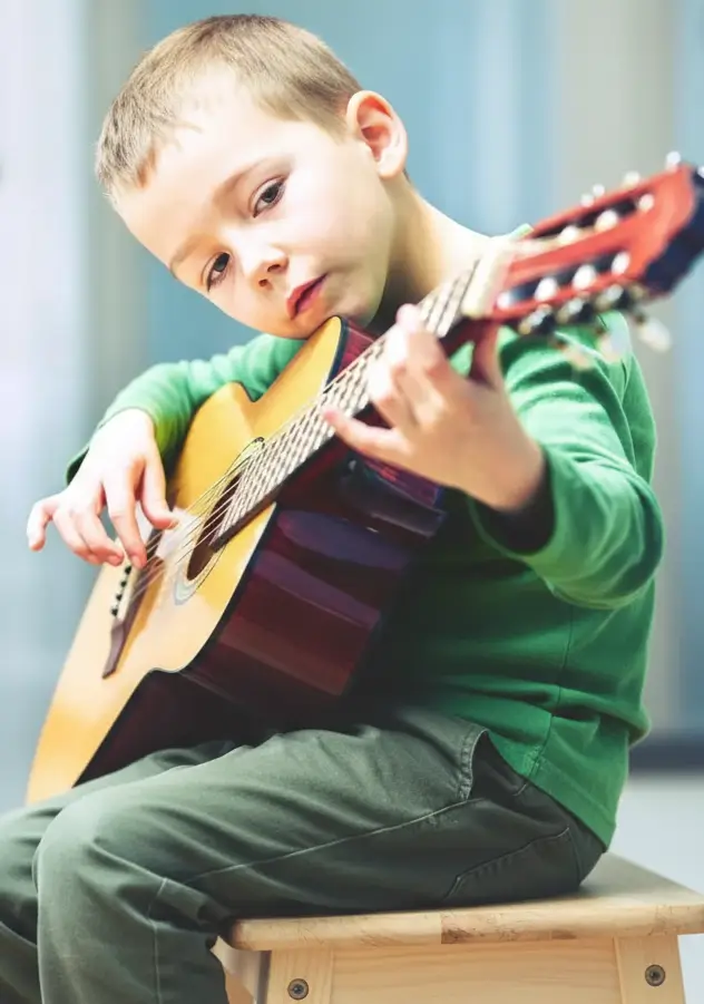 Junge beim Gitarrenunterricht